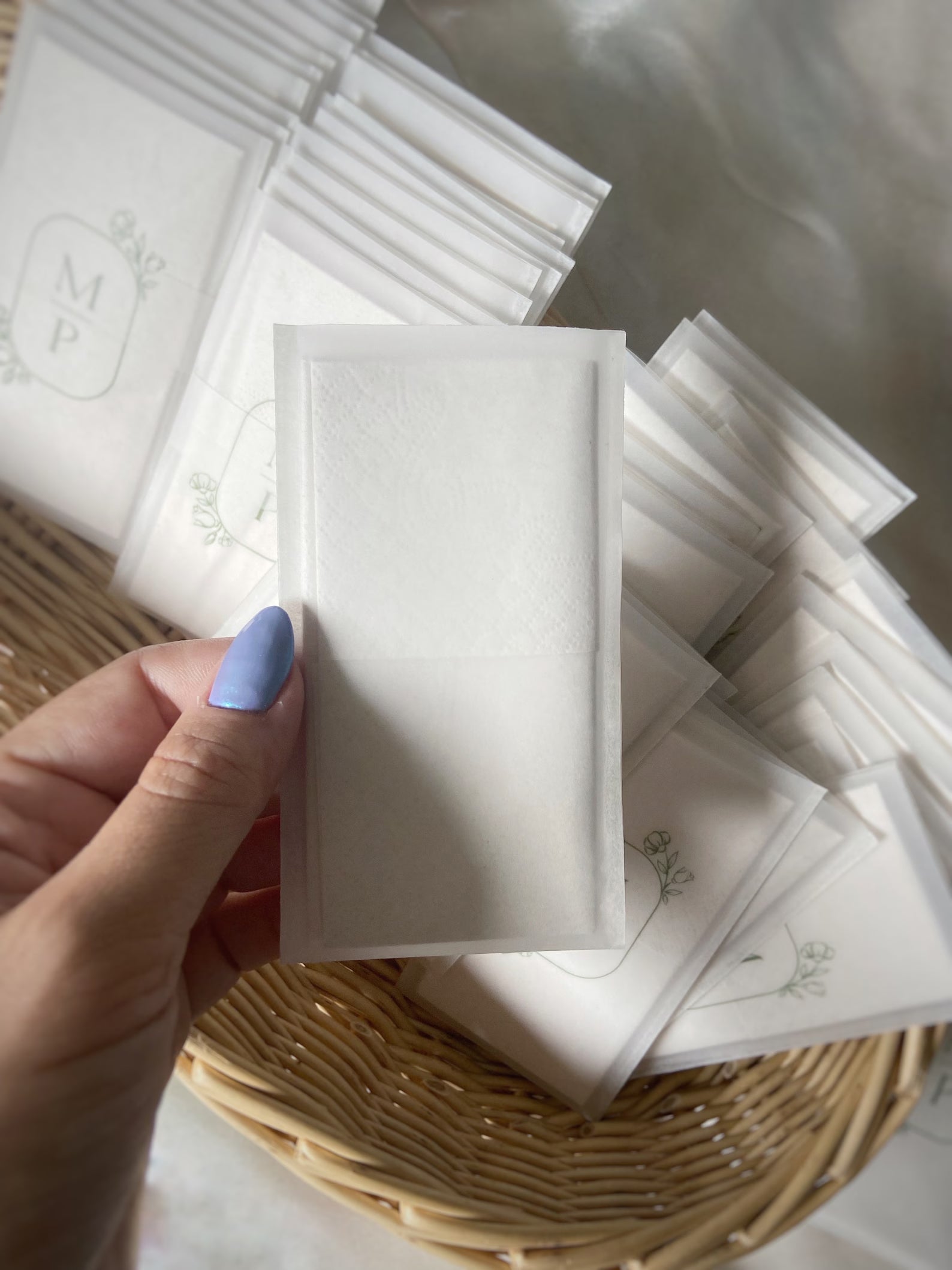 Mouchoir de mariage personnalisé dans une pochette en papier calque transparent, décorée d’un monogramme vert avec les initiales des mariés entourées d’un cercle floral. Accessoire élégant et éco-responsable pour mariage champêtre, bohème ou romantique. Idée cadeau pour invités, larmes de joie ou cérémonie de mariage sur mesure.